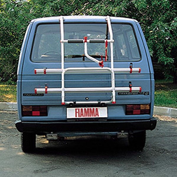 Fiamma sykkelholder montert bak på VW T3, med to skinner og justerbare klemmer for sikker transport.